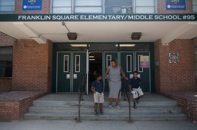 A woman and two children walking out of Franklin Square Elementary/Middle School #95